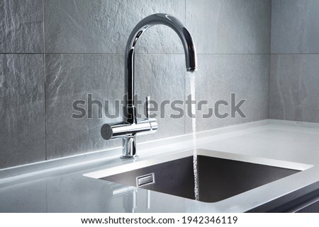 Kitchen water mixer. Water tap made of chrome material Royalty-Free Stock Photo #1942346119