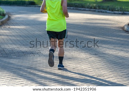 Rear view photo of young man running in the park