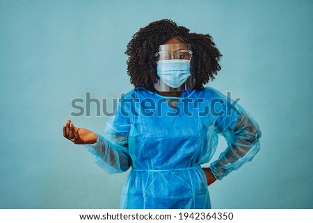 Nurse practitioner with personal protective equipment face shield goggles one hand out covid 19