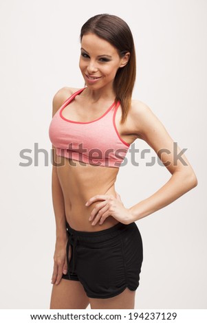 Beautiful brunette fitness woman posing on white isolated background