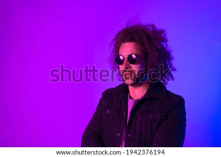Portrait of an Afro-American hipster man, afro hair, in the style of the 80s and 90s, steampunk glasses, blue and purple neon lights. smiling and laughing.
