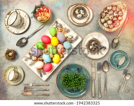 Easter flat lay with colored eggs. Festive table place setting decoration. Vintage style toned picture