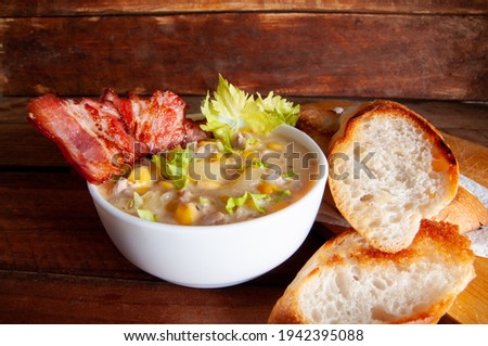 Corn chowder soup with bacon. Brown wooden background. Close-up view