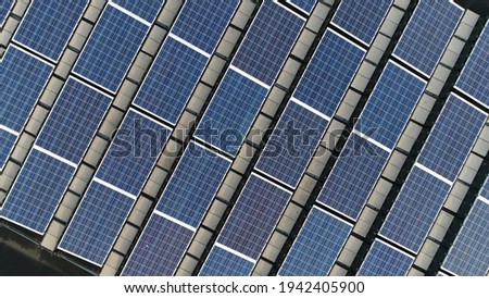 Aerial close up picture of eco-friendly solar panels mounted on roof using natural resources photo-voltaic cells which use sunlight as a source of energy and generate direct current electricity