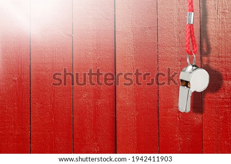 Steel sports whistle on orange background. Concept- sport competition, referee