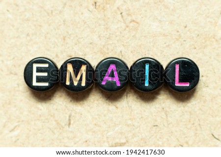 Black color round alphabet letter block in word email on wood background
