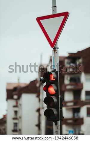 A vertical shot of a yield sign above a red traffic light