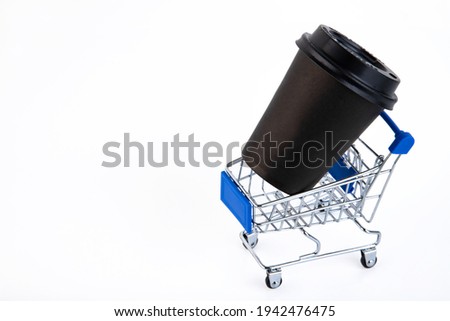 Shopping cart, e-commerce, digital commerce, retail, black paper cup, white background. Copy space.