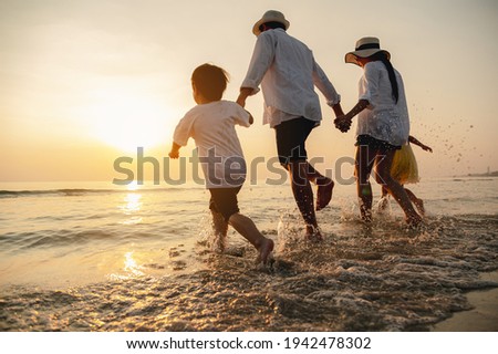 Happy asian family at consisting father, mother,son and daughter having fun playing beach in summer vacation on the beach.Happy family and vacations concept.   Royalty-Free Stock Photo #1942478302