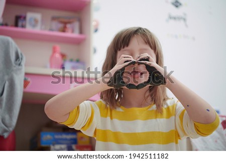 cute little girl at home painting with hands