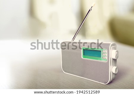 The FM channel is playing music, a stylish retro radio player stands on a table.