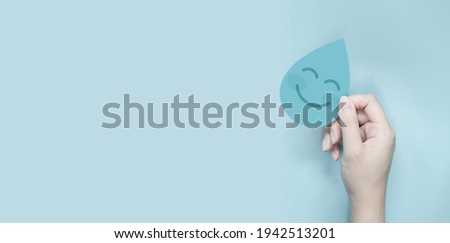world ocean day concept, woman hands holding water drop paper cut smile face, world water day, CSR, save water resource Royalty-Free Stock Photo #1942513201