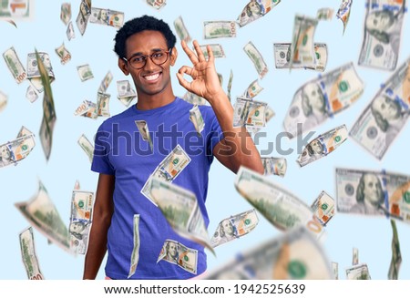 African handsome man wearing casual clothes and glasses smiling positive doing ok sign with hand and fingers. successful expression.