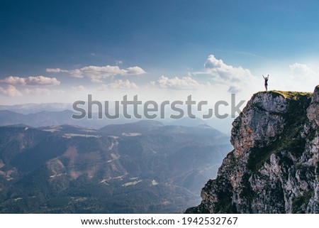 call of nature on the Otscher mountain. The girl in black sportswear stretches on a rock massif. Dangerous place. View of the Austrian Alps. Mountain girl on the edge of a rock. Royalty-Free Stock Photo #1942532767