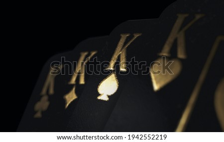 A fanned out suit of four black king casino playing cards with gold markings on a dark classy background - 3D render