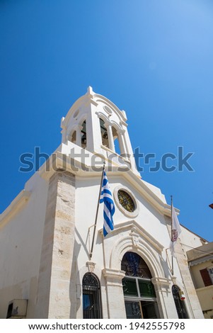 White Orthodox Church with Blue Sky and a Greek Flag in rethymnon, Crete. High quality photo