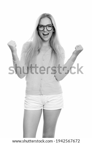 Studio shot of young happy teenage girl smiling while looking excited