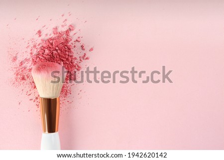 Makeup brush and scattered blush on pink background, top view. Space for text Royalty-Free Stock Photo #1942620142