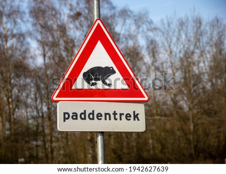 Paddentrek. Dutch triangular warning or traffic sign. Beware,frog migration or pairing toads in spring period. Caution, crossing the road. Part of a series