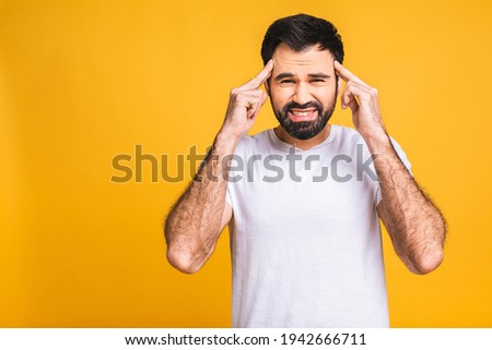 People, crisis, emotions and stress concept - unhappy tired man suffering from head ache at home. Isolated over yellow background.  Royalty-Free Stock Photo #1942666711