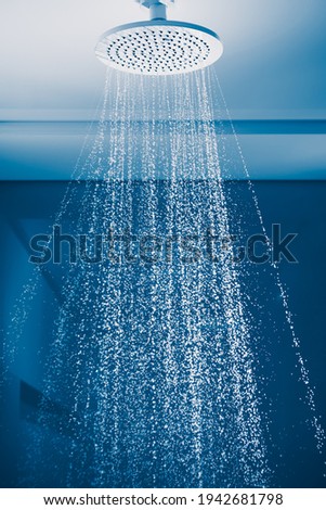 douche with water stream, blue background Royalty-Free Stock Photo #1942681798
