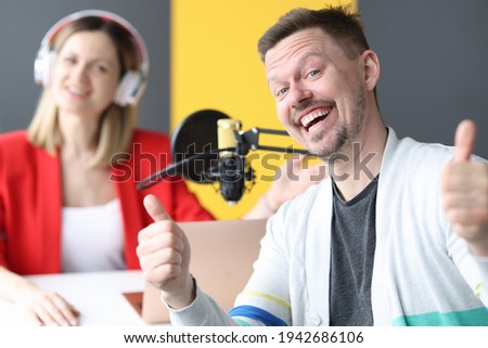 Joyful man and woman are working on air of radio station