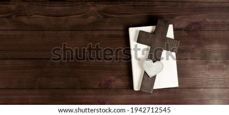 Closed books holy bible. Scripture. Cross of Jesus. Heart. On a wooden background