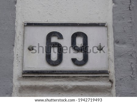 A sign on a wall with the number sixty-nine - 69
