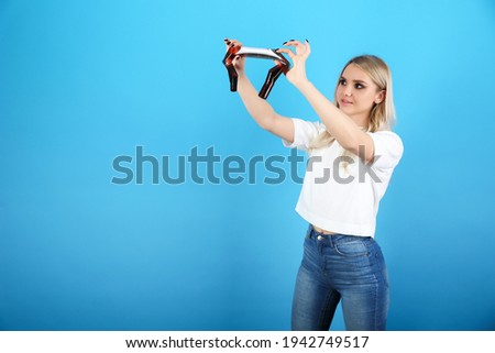 young woman watching film of photo camera on a blue background. viewing captured photos on film