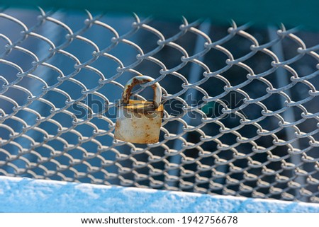 Rusty padlock on a fence at a bridge