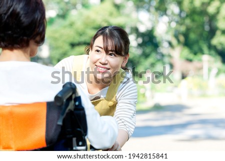 Female caregiver talking to a senior woman in a wheelchair