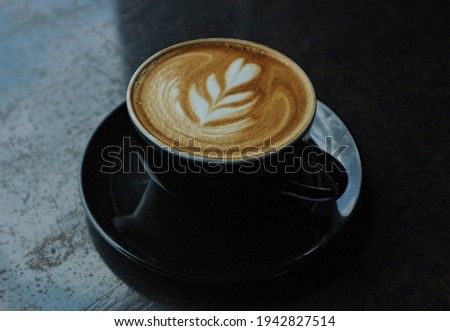 A cup of latte coffee on a black table with reflected light in the window Royalty-Free Stock Photo #1942827514