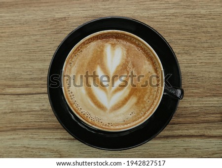 A cup of latte coffee on a wooden table Royalty-Free Stock Photo #1942827517