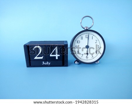 Alarm clock isolated on blue background with date July 24