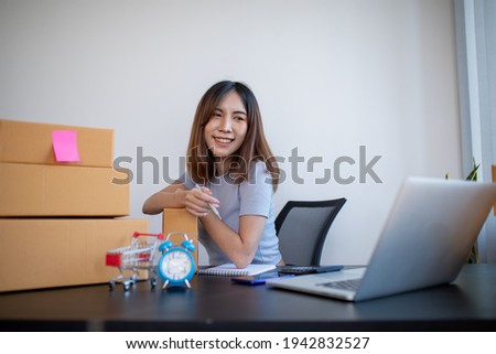 Small business entrepreneur SME freelance,Portrait young woman working on laptop at home office, online marketing packaging delivery box, SME e-commerce concept