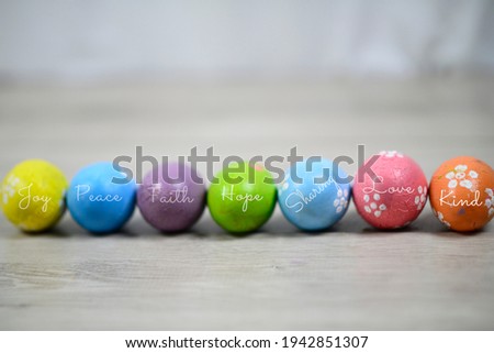 Easter backgrounds with eggs. Bright and colorful Easter eggs lined up horizontally on a white wooden background. Easter egg with kind positive single word. Happy April holiday concept backgrounds.