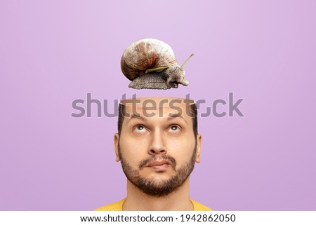 Slow brain concept, problems with head functions, alzheimer's. A man has a snail in his head instead of a brain