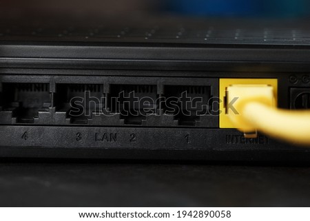 Wireless modem router with yellow cable and LAN port for connection on a black background. wireless LAN technology with devices based on IEEE 802.11 standards