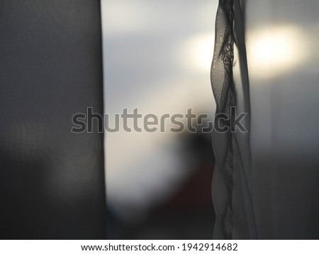 A closeup of transparent curtains over windows with a blurry background