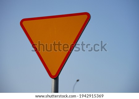 A closeup shot of a yellow yield sign