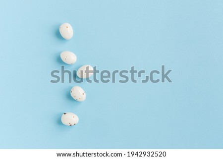 Easter minimal composition with eggs on the blue background. Easter concept. Copy space, flat lay.