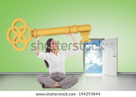 Composite image of businesswoman sitting holding large key against door opening showing blue sky