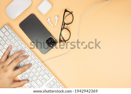 People using typing keyboard, phone, mouse, glasses and headphones. Nicotine color background.