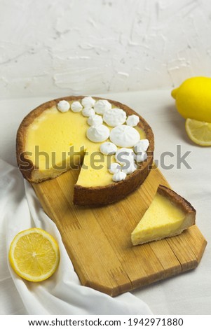 Slice of Lemon Meringue Pie. Traditional French Tart. Homemade dessert. Piece of cake on wooden board.