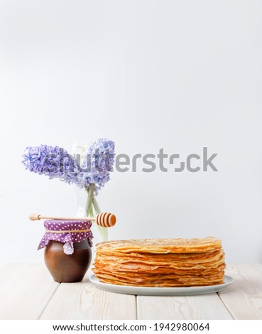 Stack Of Crepes With Honey Clay Jug And Spring Flowers On Wooden Table. Side View, Copy Space.