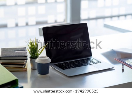 Image of laptop computer and a coffee mug placed on the desk.