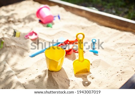 Sandbox outdoor. Children's wooden sandbox with various toys for the game. Summer concept. Selective focus with shallow depth of field Royalty-Free Stock Photo #1943007019