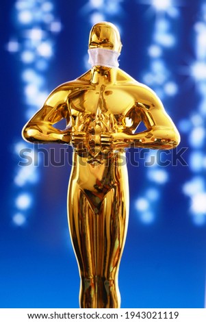 Hollywood Golden Oscar Academy award statue in medical mask. Success and victory concept. Oscar ceremony in coronavirus time