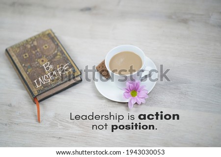 Inspirational quote - Leadership is action not position. Business concept with motivational words, a cup of morning coffee, purple flower and cookies, a notebook written be inspire on book cover.