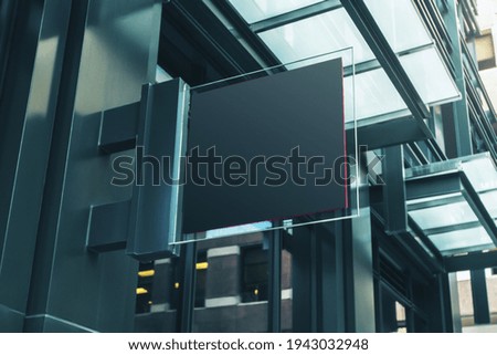Black square signboard with blank space for your logo on the wall of a modern shopping center, mockup